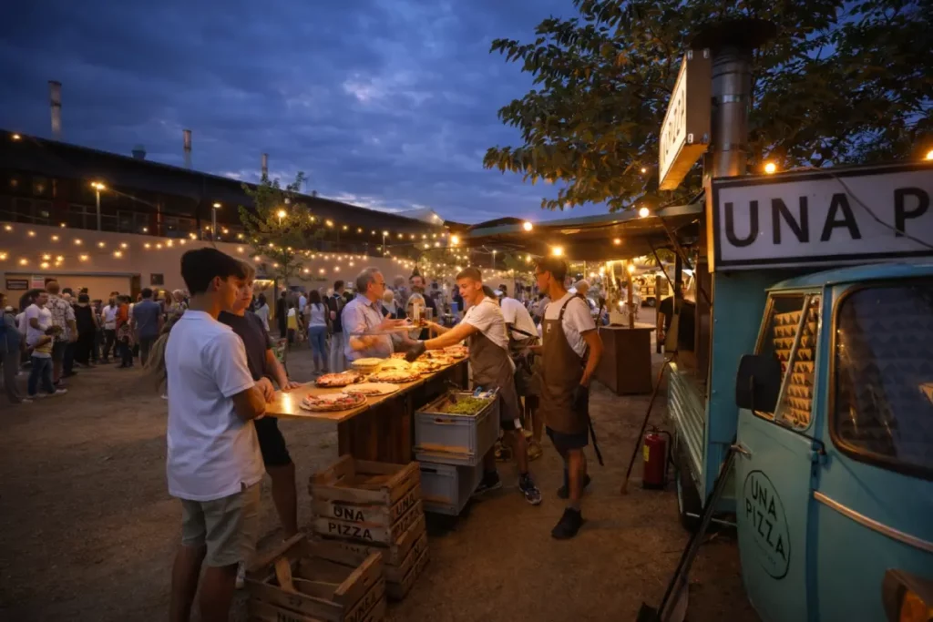 Stand de comida en la Mostra Gastronómica Cabrils con asistentes degustando platos en ambiente festivo nocturno