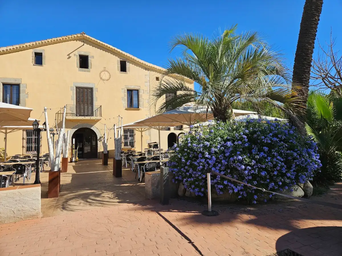 Terraza de restaurante en masía tradicional Mas Padellas de Teià con mesas exteriores y vegetación mediterránea